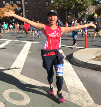 Runner smiling with arms spread wide at at NYC Marathon for Girls on the Run NYC!